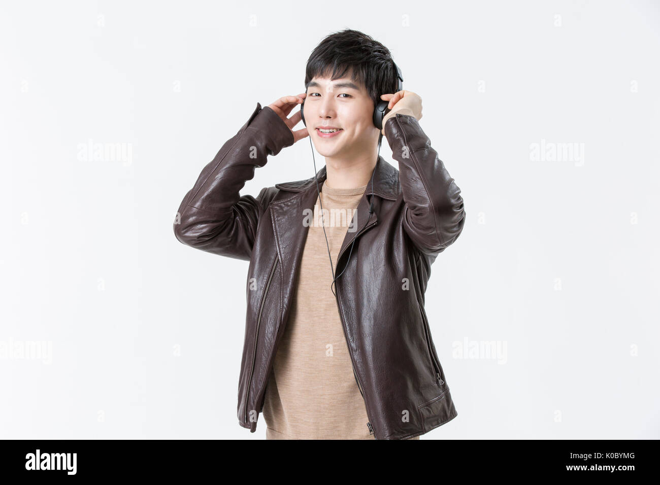 Portrait of young smiling man listening to music Banque D'Images