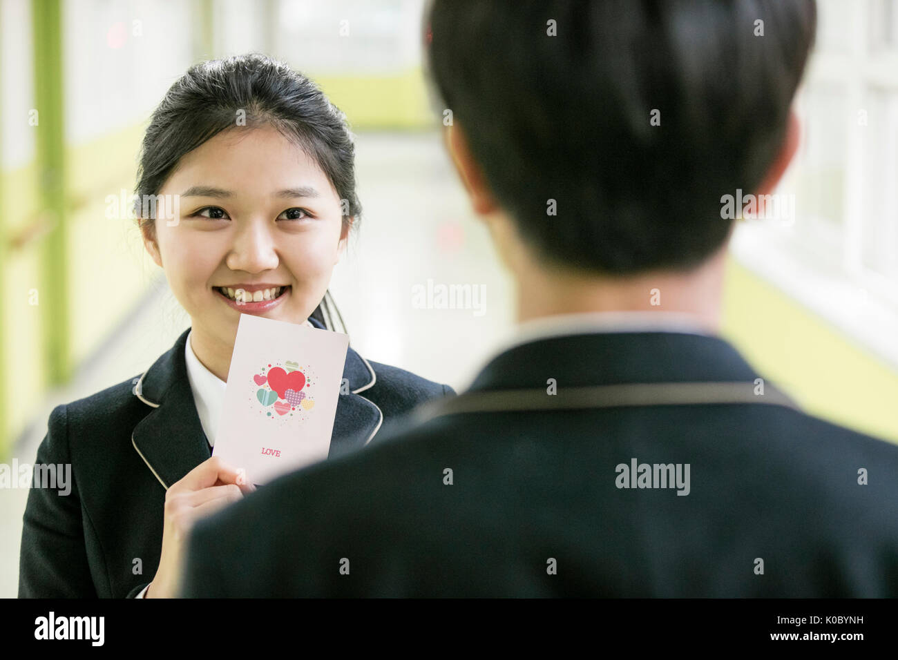 Portrait of smiling fille de l'école montrant une carte pour un garçon de l'école Banque D'Images