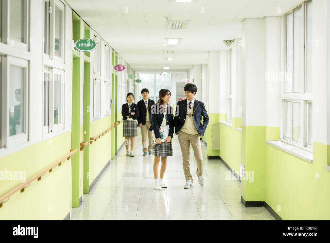 Les élèves de l'école sourire marche à couloir à l'école Banque D'Images