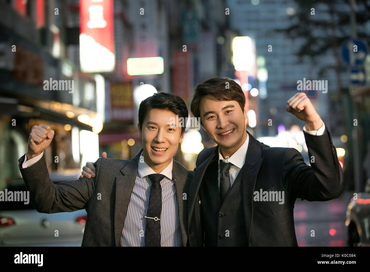 Portrait of two smiling businessmen posing at night Banque D'Images