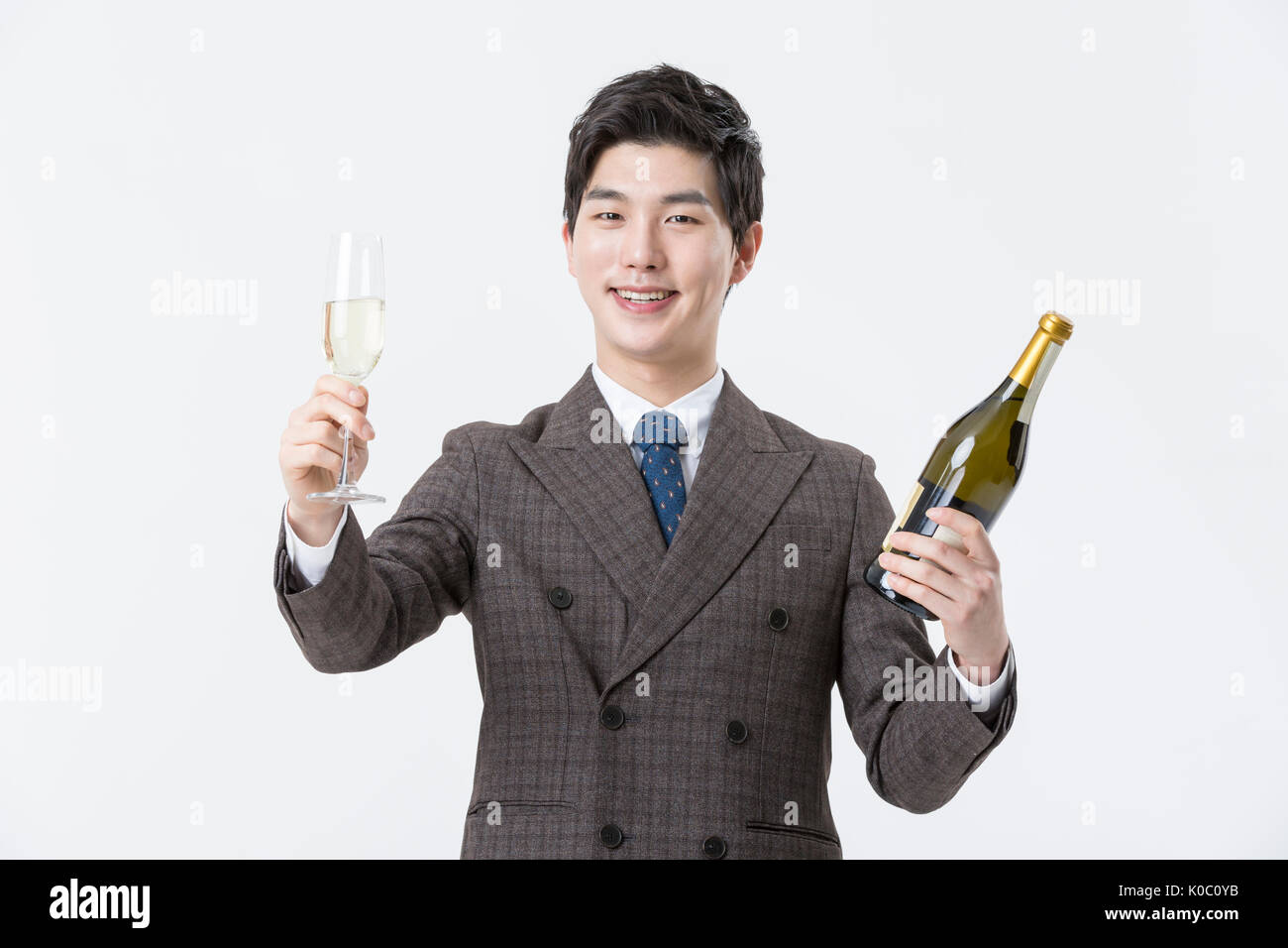 Portrait of young smiling businessman holding champagne bouteille de champagne et verre Banque D'Images