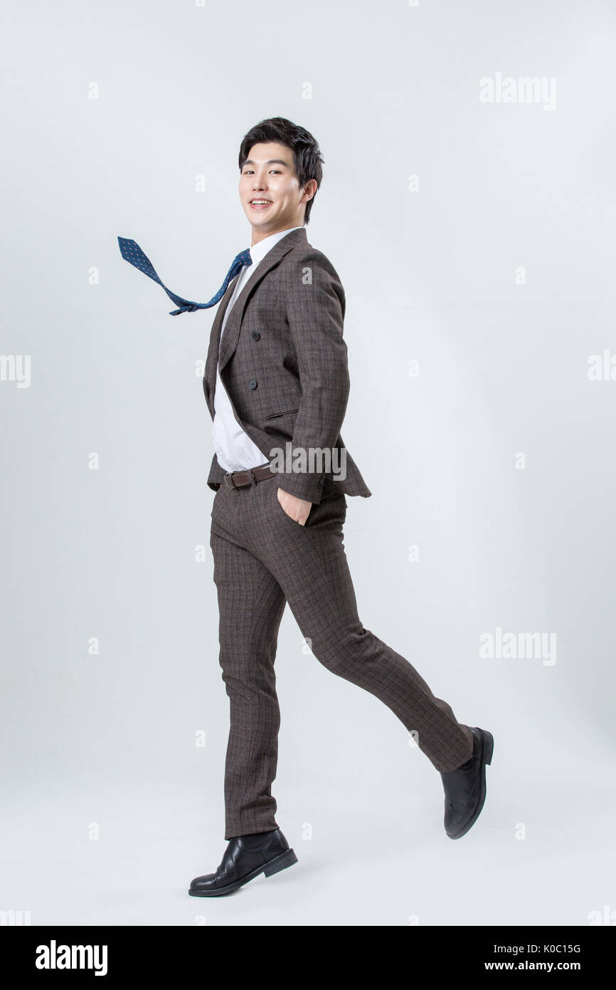 Side view of young smiling man jumping Banque D'Images