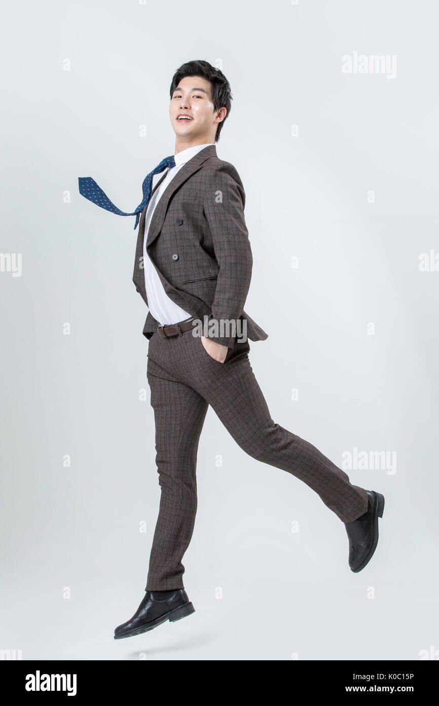 Side view of young smiling man jumping Banque D'Images