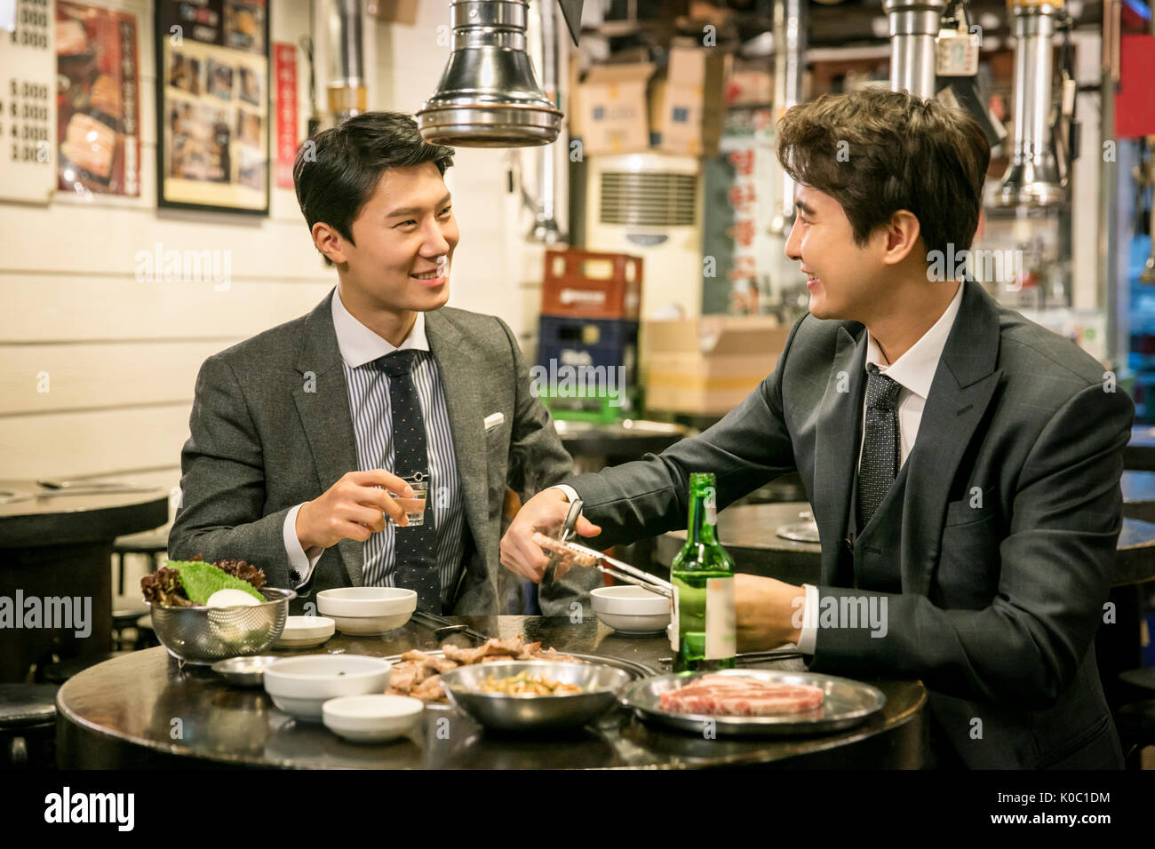 Deux smiling businessmen having a parler de boire Banque D'Images