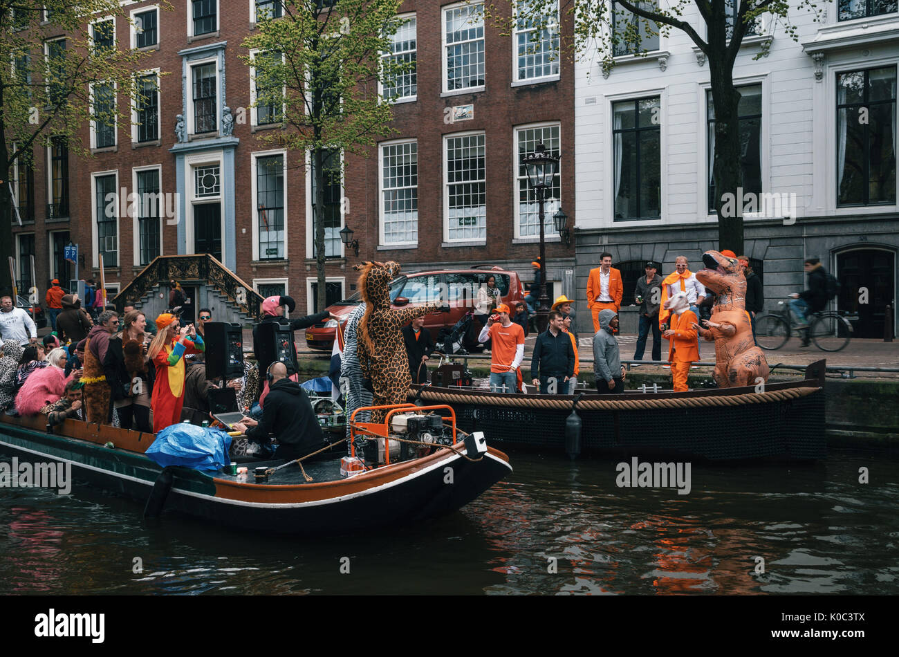Amsterdam, Pays-Bas - 27 avril, 2017 : la population locale et les touristes habillés de vêtements orange et des costumes amusants ride sur les bateaux et participer à de célébrité Banque D'Images