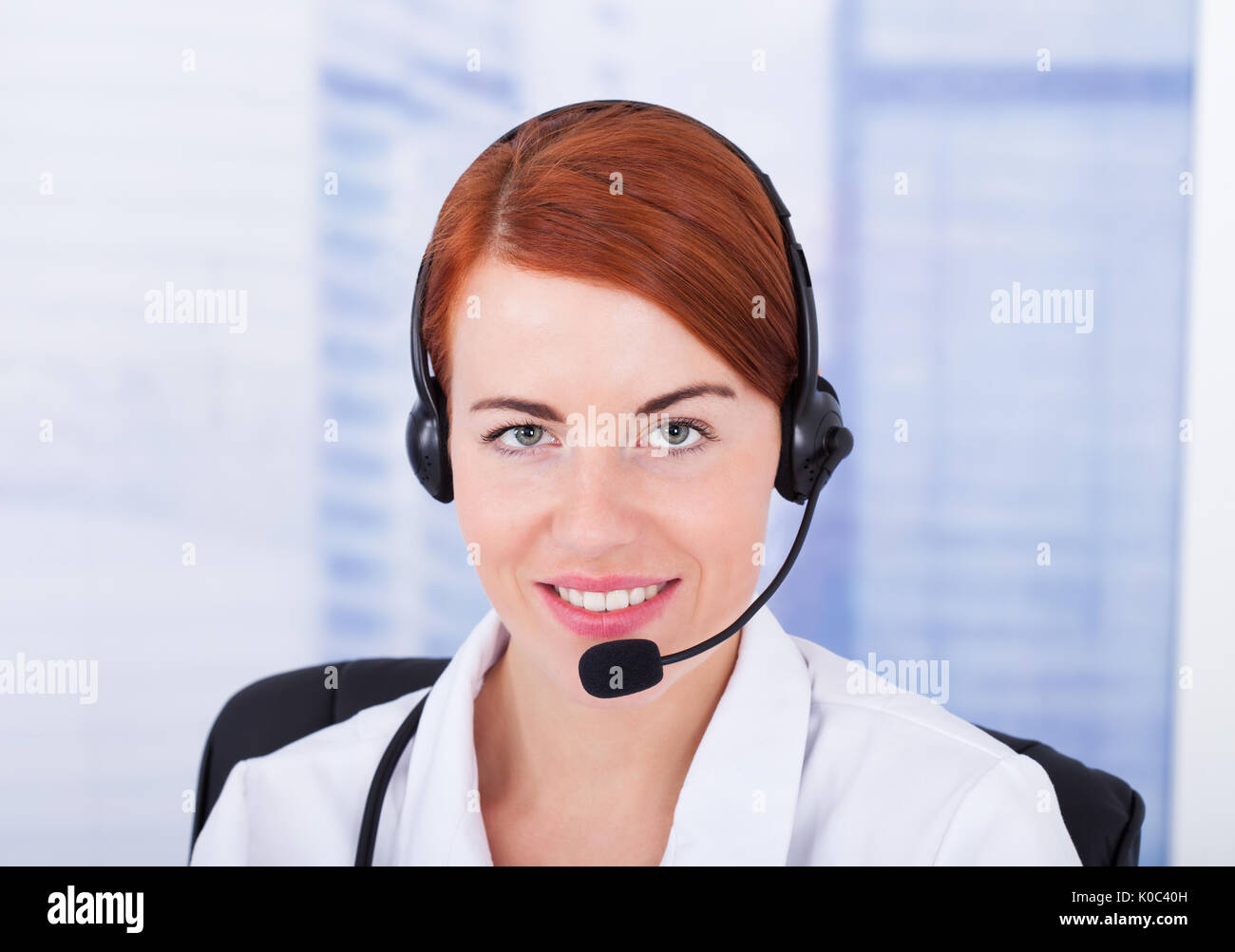 Closeup of smiling female customer service representative avec microphone Banque D'Images