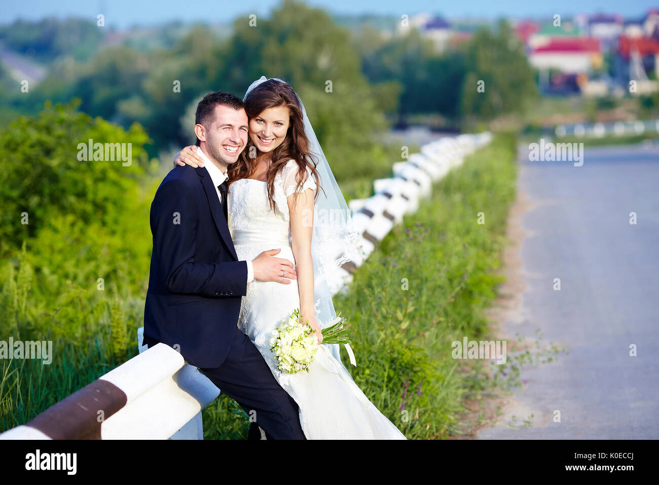 Happy Bride and Groom smiling rire sur la route sur un mariage. Banque D'Images