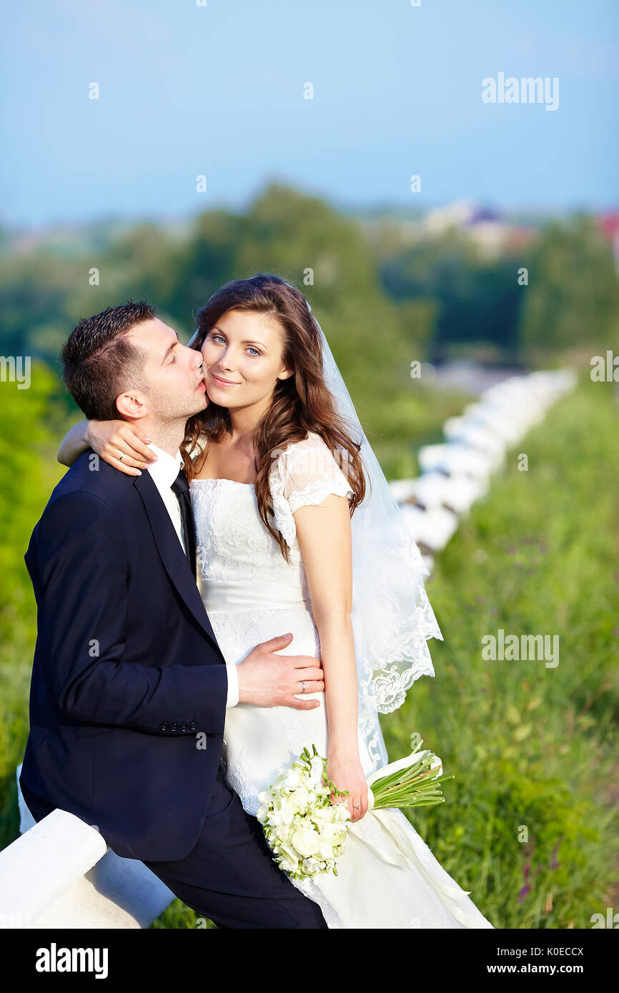 Happy Bride and Groom kissing smiling sur jour de mariage. Banque D'Images