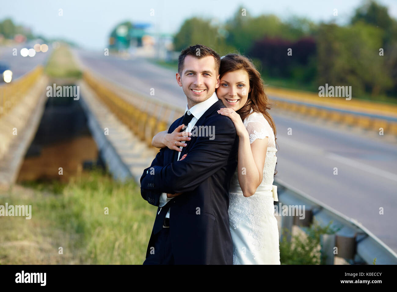 Happy Bride and Groom smiling rire sur la route sur un mariage Banque D'Images