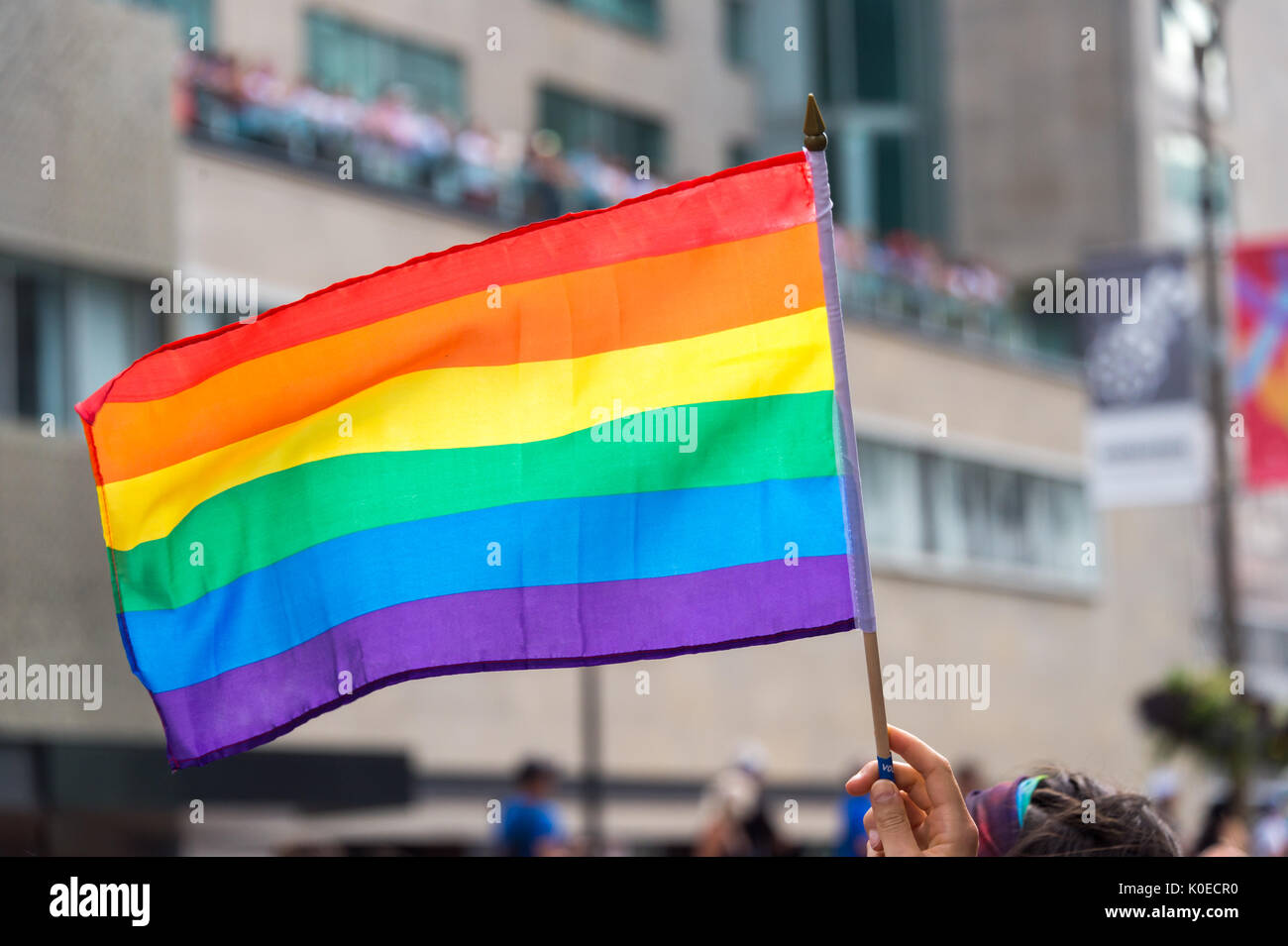 Gay de brandir le drapeau arc-en-ciel dans le vent Banque D'Images