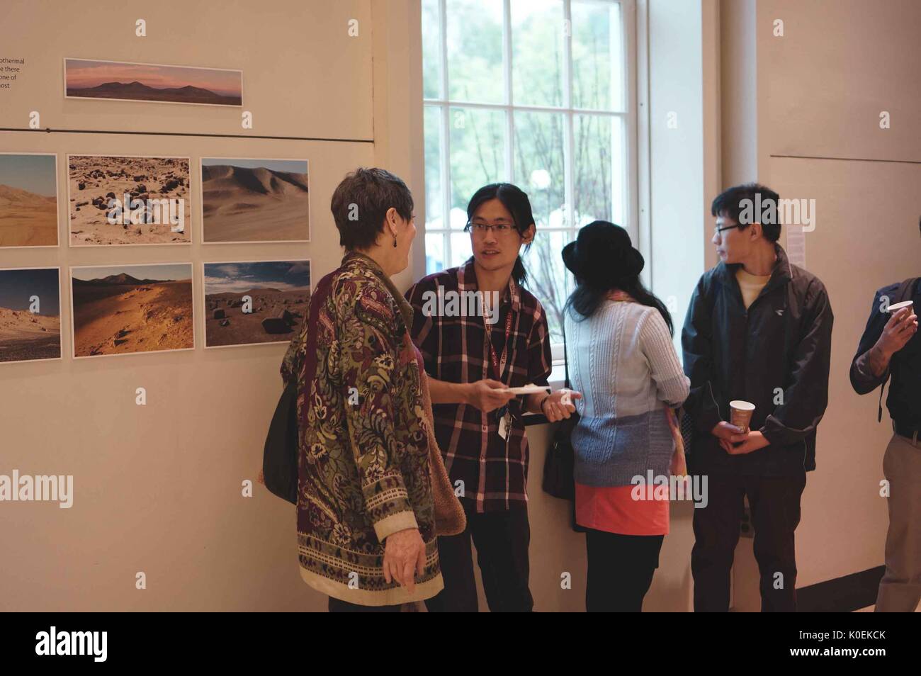 Les étudiants et membres de l'université Johns Hopkins et communautés mica socialiser et observer des objets sur l'écran d'ouverture de retour à la terre : la préparation d'un voyage vers Mars, une exposition et la collaboration entre le Maryland Institute College of Art (mica) et l'université Johns Hopkins, qui a eu lieu à la galerie q dans le milton s. Eisenhower Library sur l'homewood campus de l'université Johns Hopkins de Baltimore, Maryland. peut, 2014. courtesy eric chen. Banque D'Images
