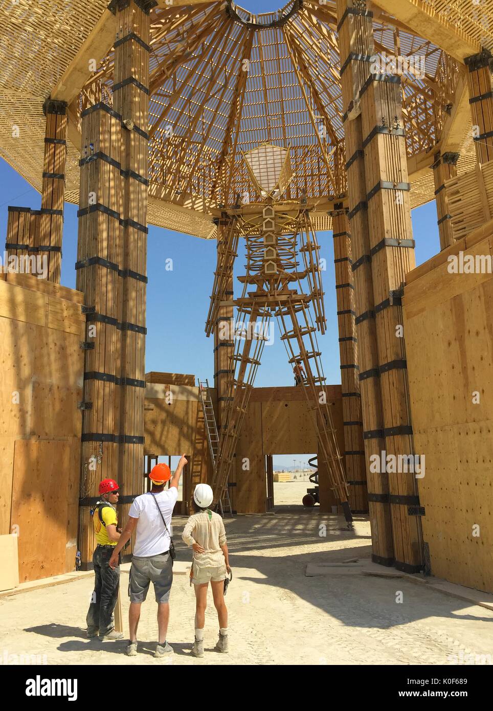 Les inspecteurs de sécurité inspecter le Burning Man sculpture au centre de la playa avant le début de l'assemblée annuelle du festival Burning Man dans le désert, le 21 août 2017 Black Rock City, Nevada. Le festival annuel attire 70 000 visiteurs dans l'une des régions les plus isolées et les déserts inhospitaliers en Amérique. Banque D'Images