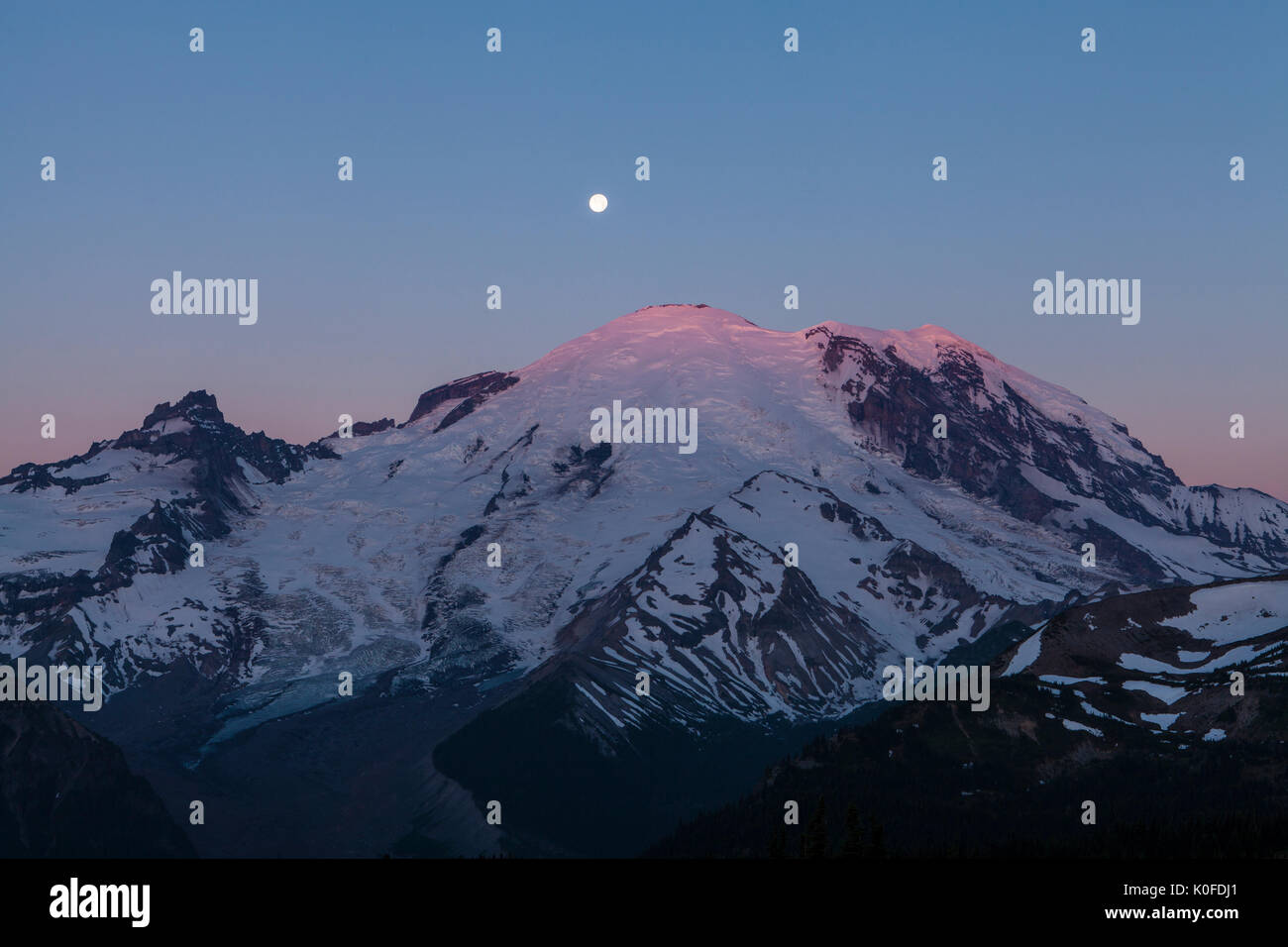 Une pleine lune sur Mt. Rainierat le lever du soleil, le Mont Rainier National Park, Washington, USA. Banque D'Images