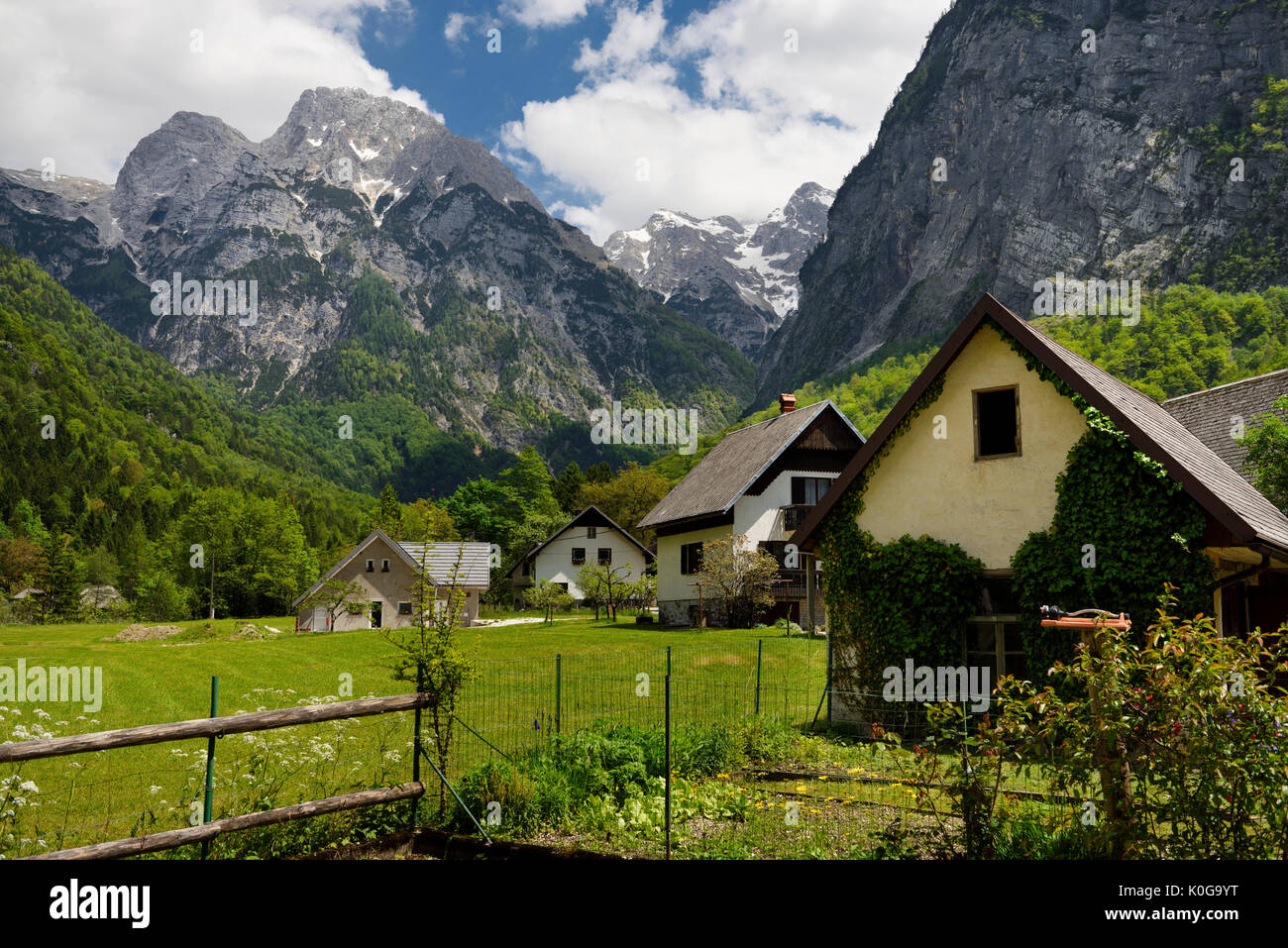 Jardin et maisons à Trenta Slovénie avec Pihavec Triglav et des pics de montagne dans le parc national du Triglav Alpes Juliennes au printemps Banque D'Images