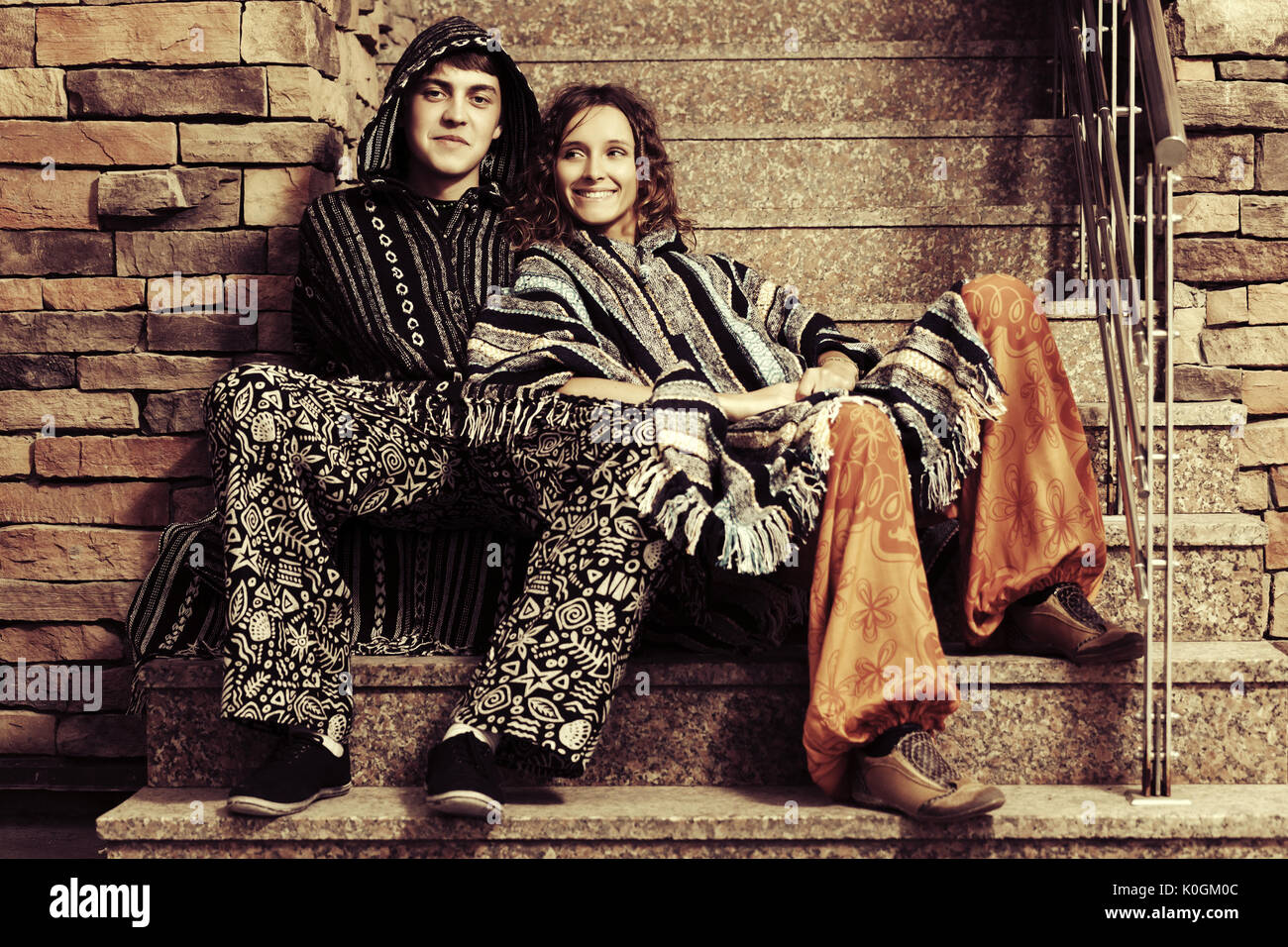 Mode jeune couple hippie assise sur les marches Banque D'Images