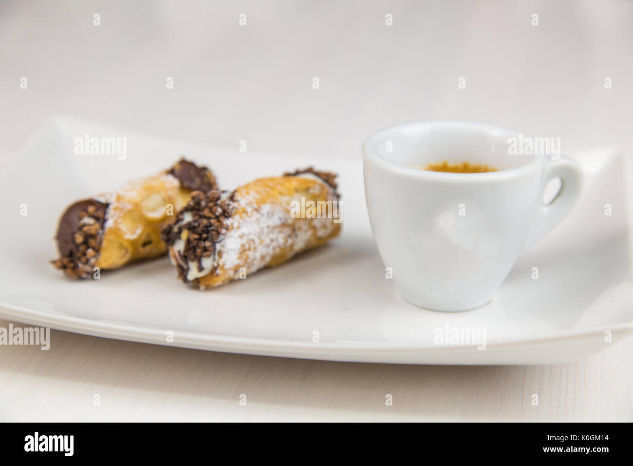 Cannoli siciliens et du café à plat sur une table en bois blanc Banque D'Images