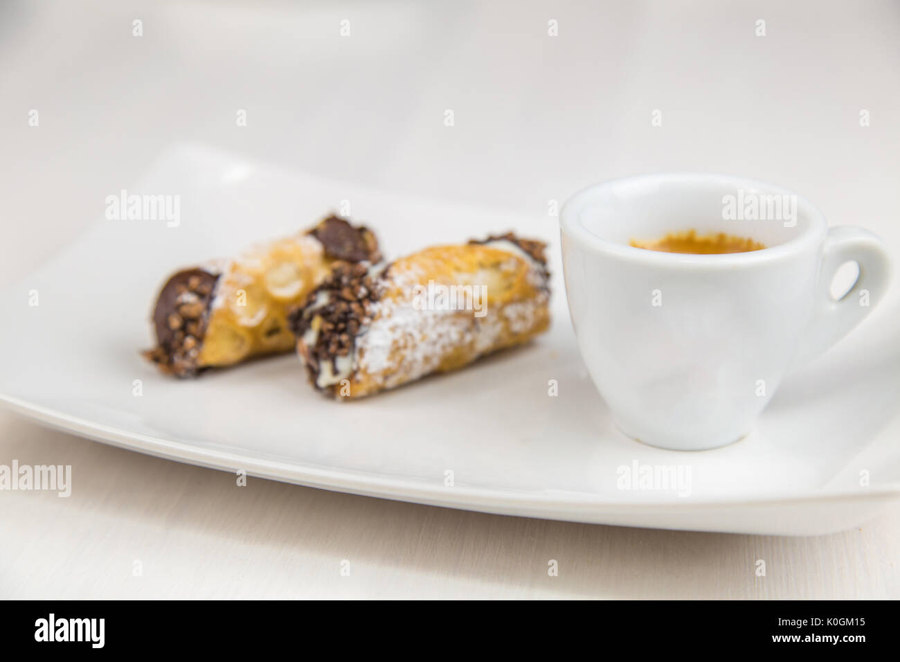 Cannoli siciliens et du café à plat sur une table en bois blanc Banque D'Images