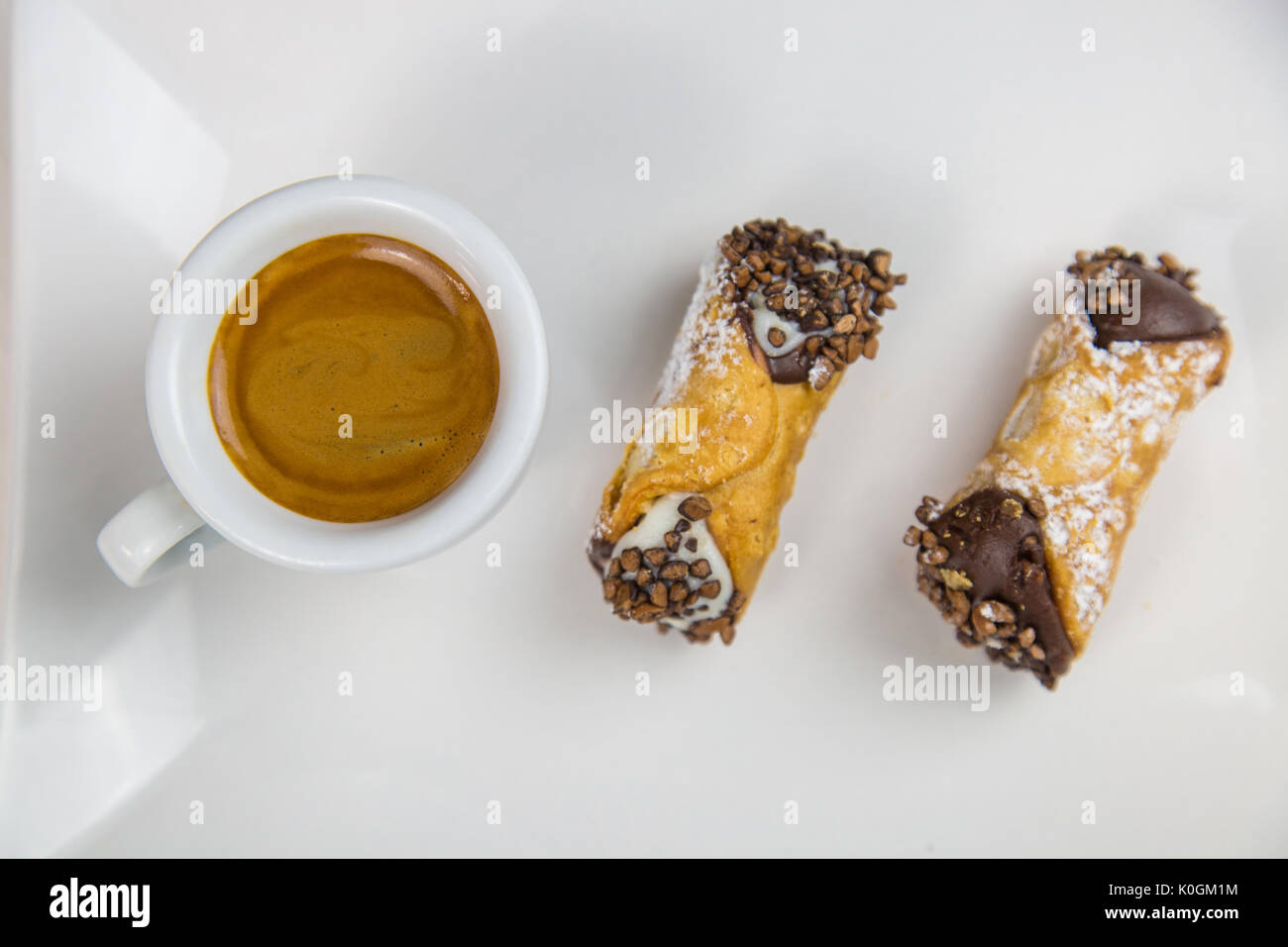 Cannoli siciliens et du café à plat sur une table en bois blanc Banque D'Images