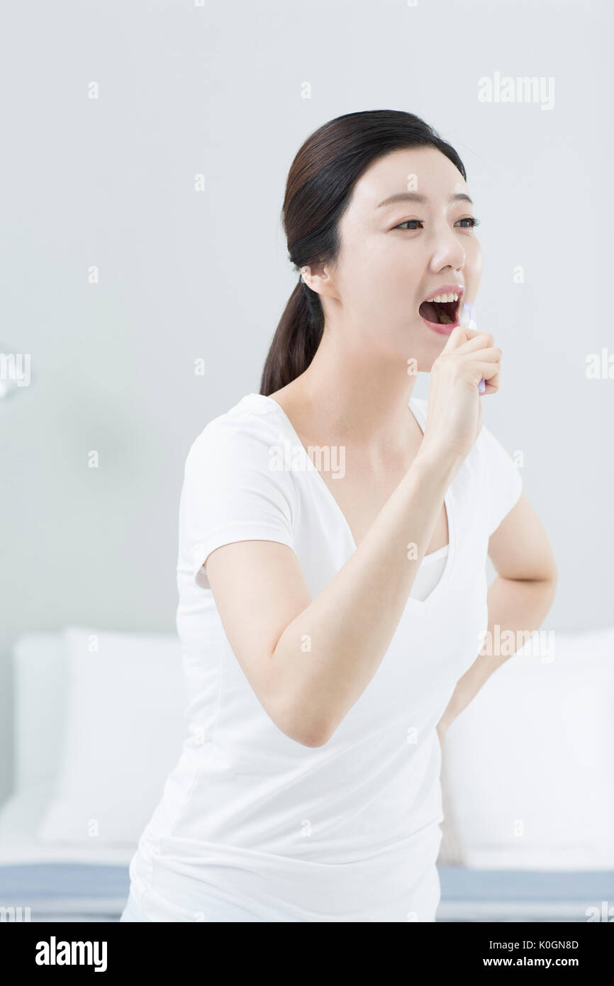 Femme souriante se brosser les dents Banque D'Images