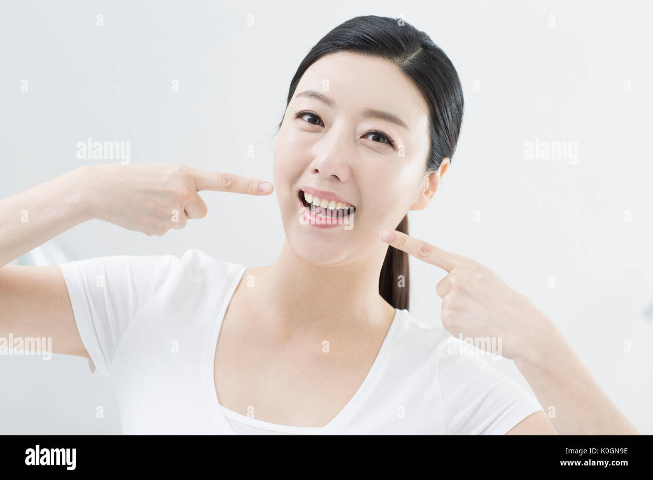 Portrait of smiling woman pointing à ses dents propres Banque D'Images
