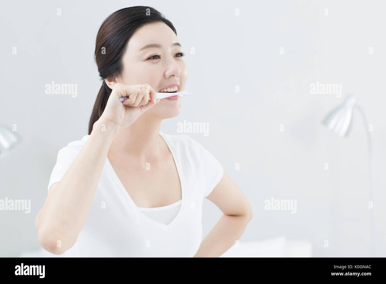 Portrait of smiling woman se brosser les dents Banque D'Images