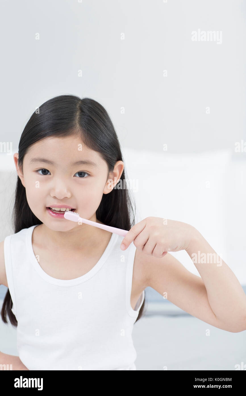 Portrait of smiling girl se brosser les dents Banque D'Images