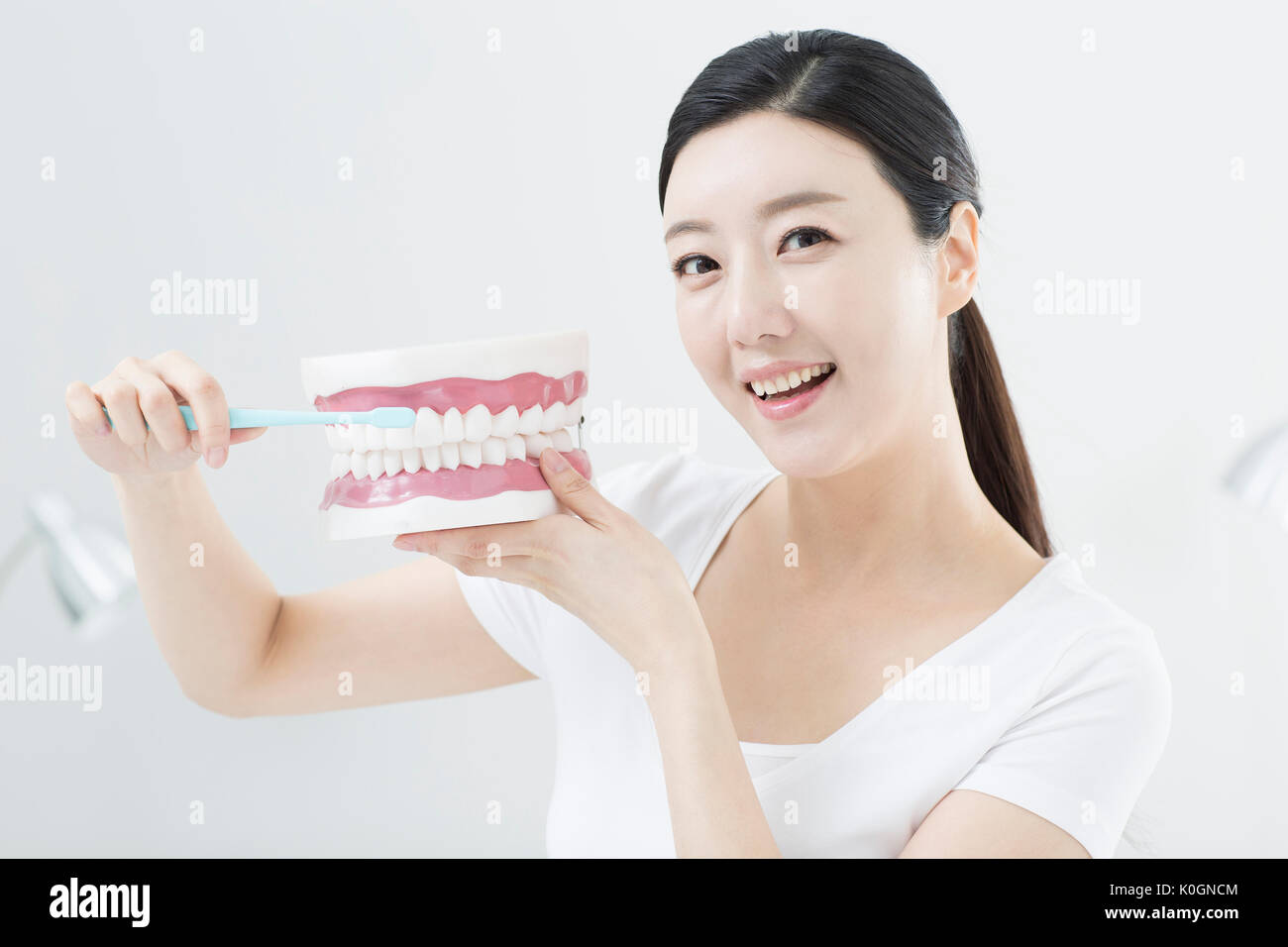 Portrait of smiling woman montrant comment brosser les dents correctement Banque D'Images