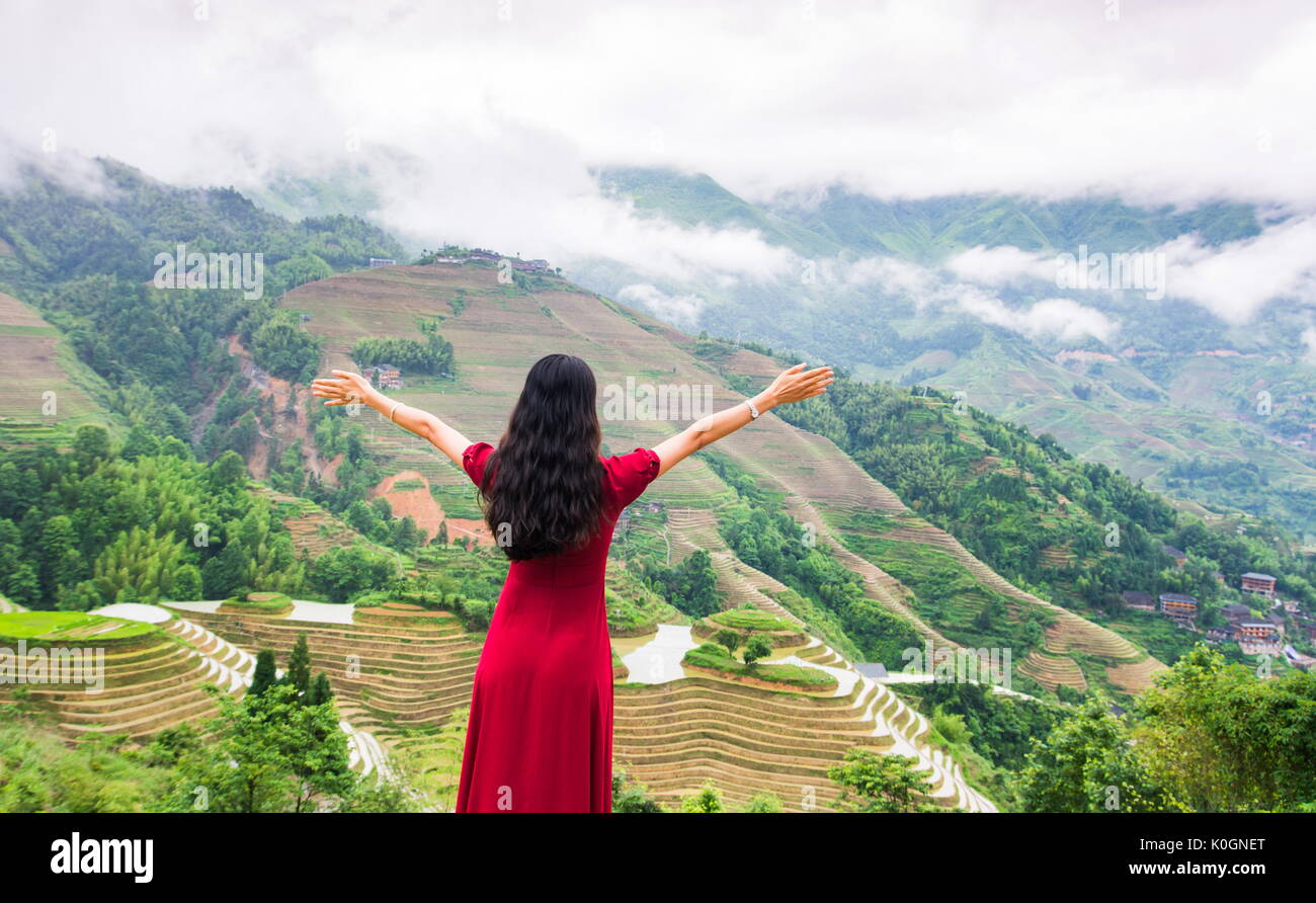 Girl enjoying vue terrasse de riz portant robe rouge Banque D'Images Girl enjoying vue terrasse de riz portant robe rouge Banque D'Images