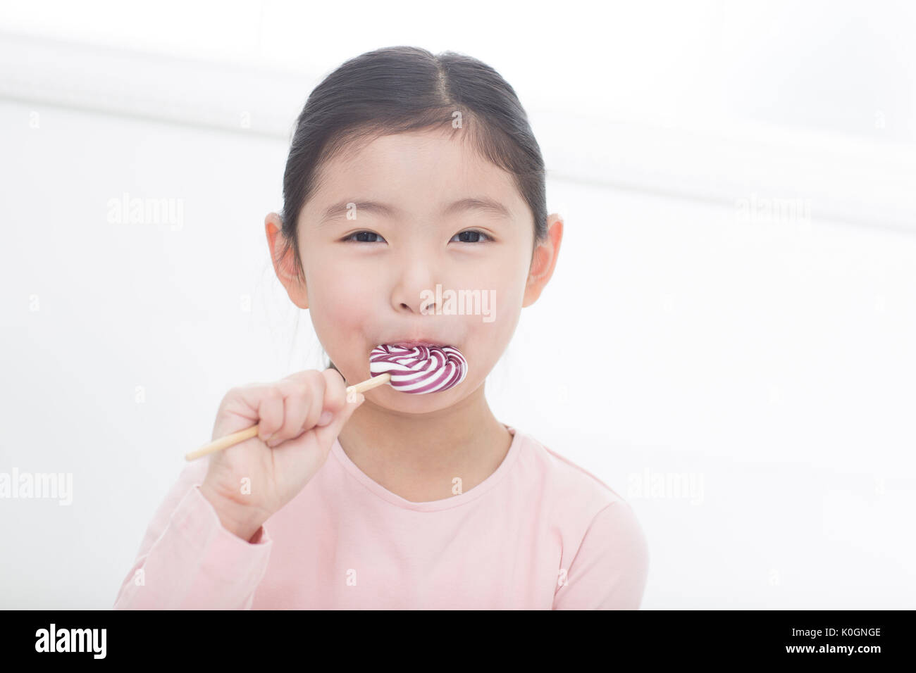 Portrait of smiling girl eating lollipop Banque D'Images