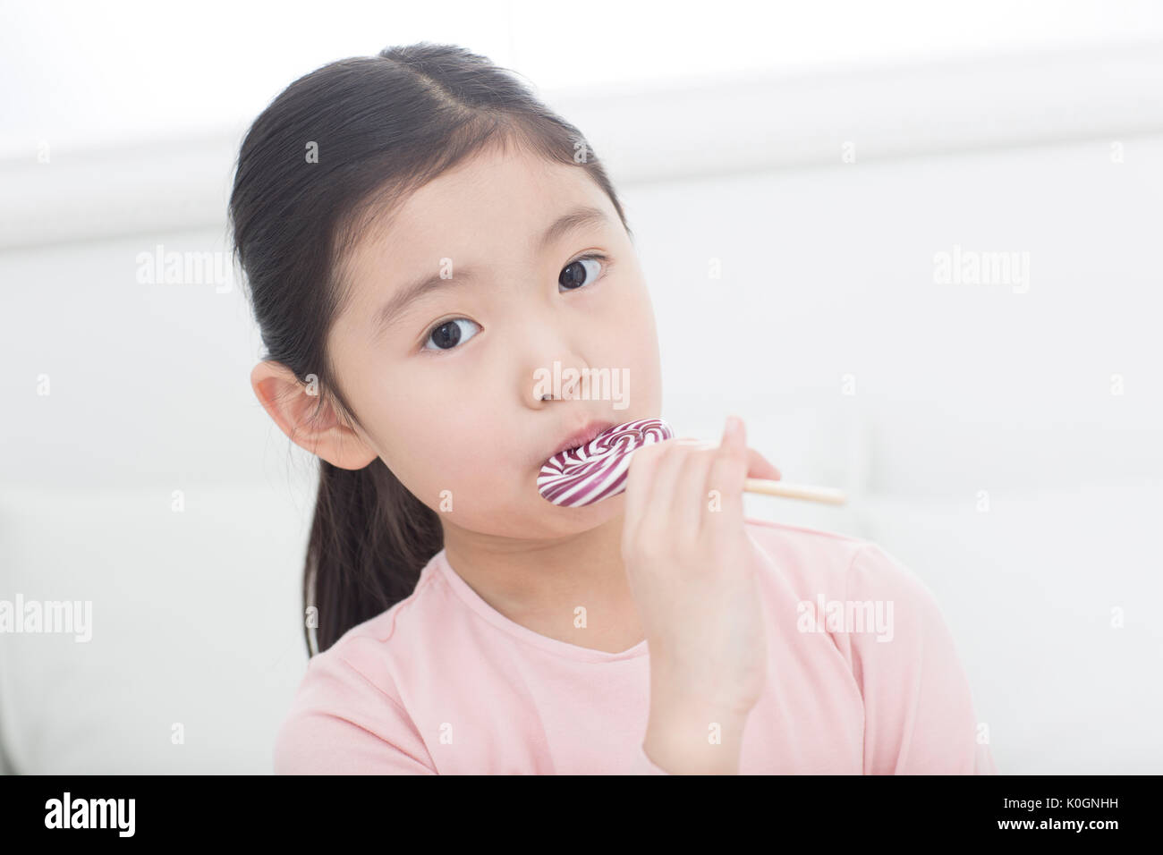 Portrait of Girl eating lollipop Banque D'Images