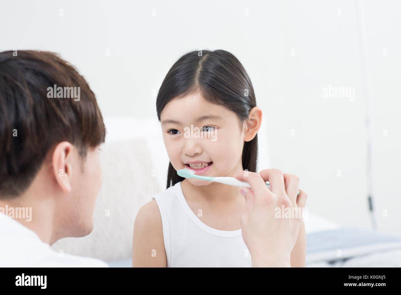 Portrait of smiling girl et son père se brosser les dents Banque D'Images