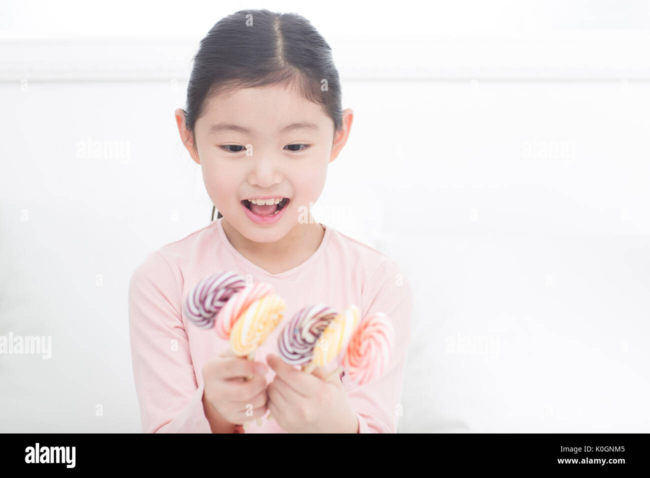Portrait of smiling girl avec lollipops Banque D'Images