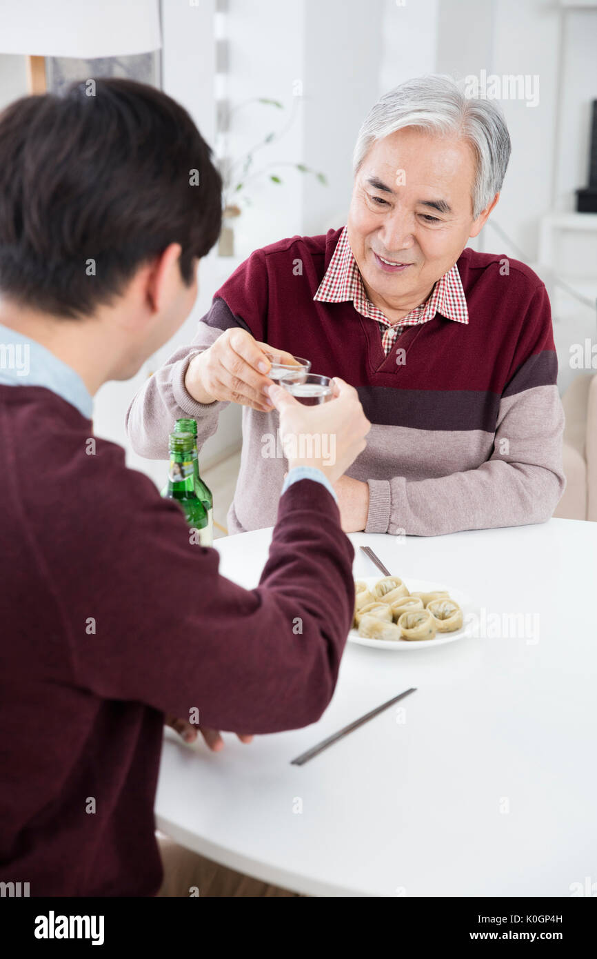 Portrait of smiling senior père et son jeune fils de boire Banque D'Images