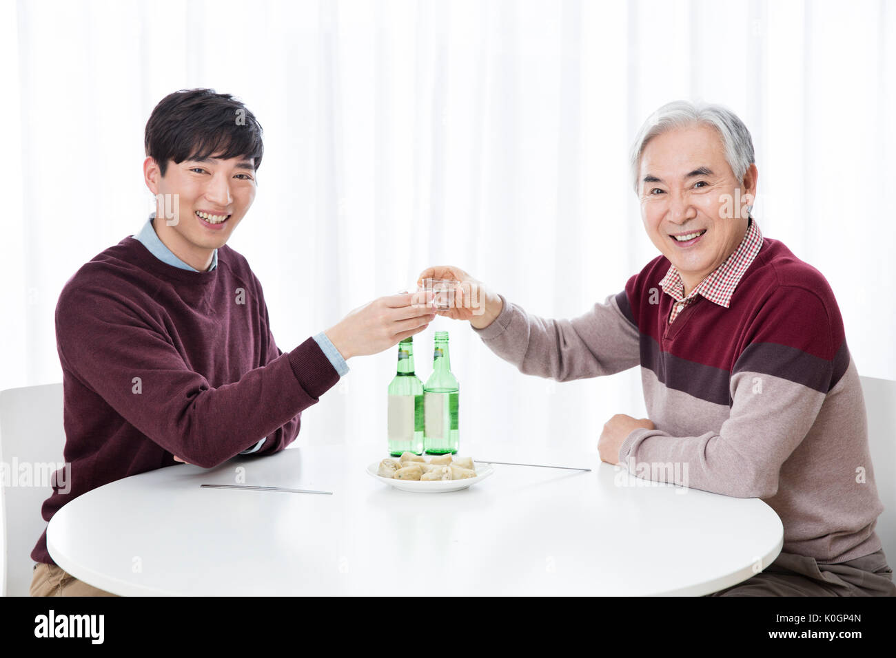 Portrait of smiling fils et ses hauts père de boire Banque D'Images