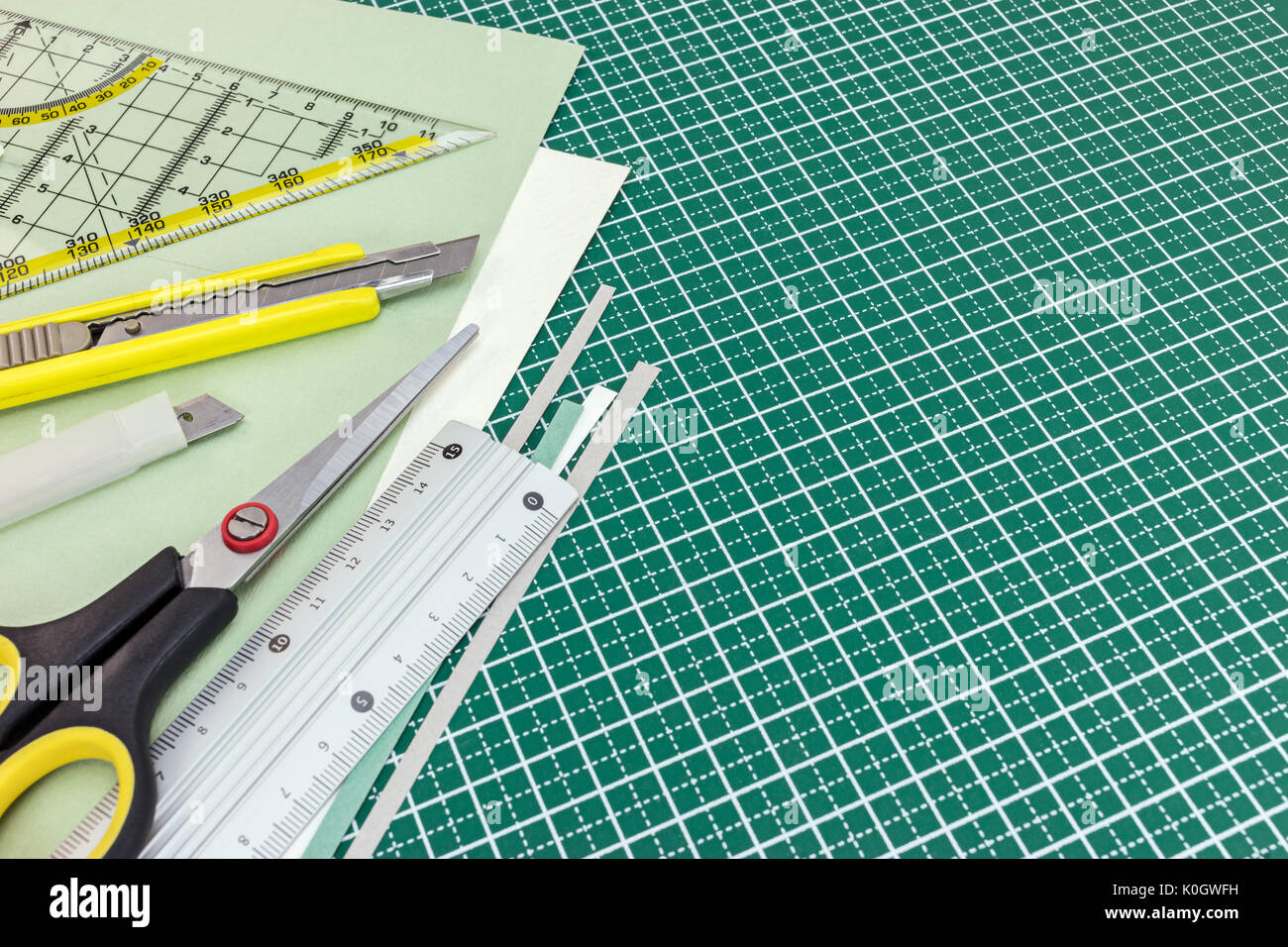 Des feuilles de papier, ciseaux, jaune et vert de la règle de fond tapis de coupe Banque D'Images