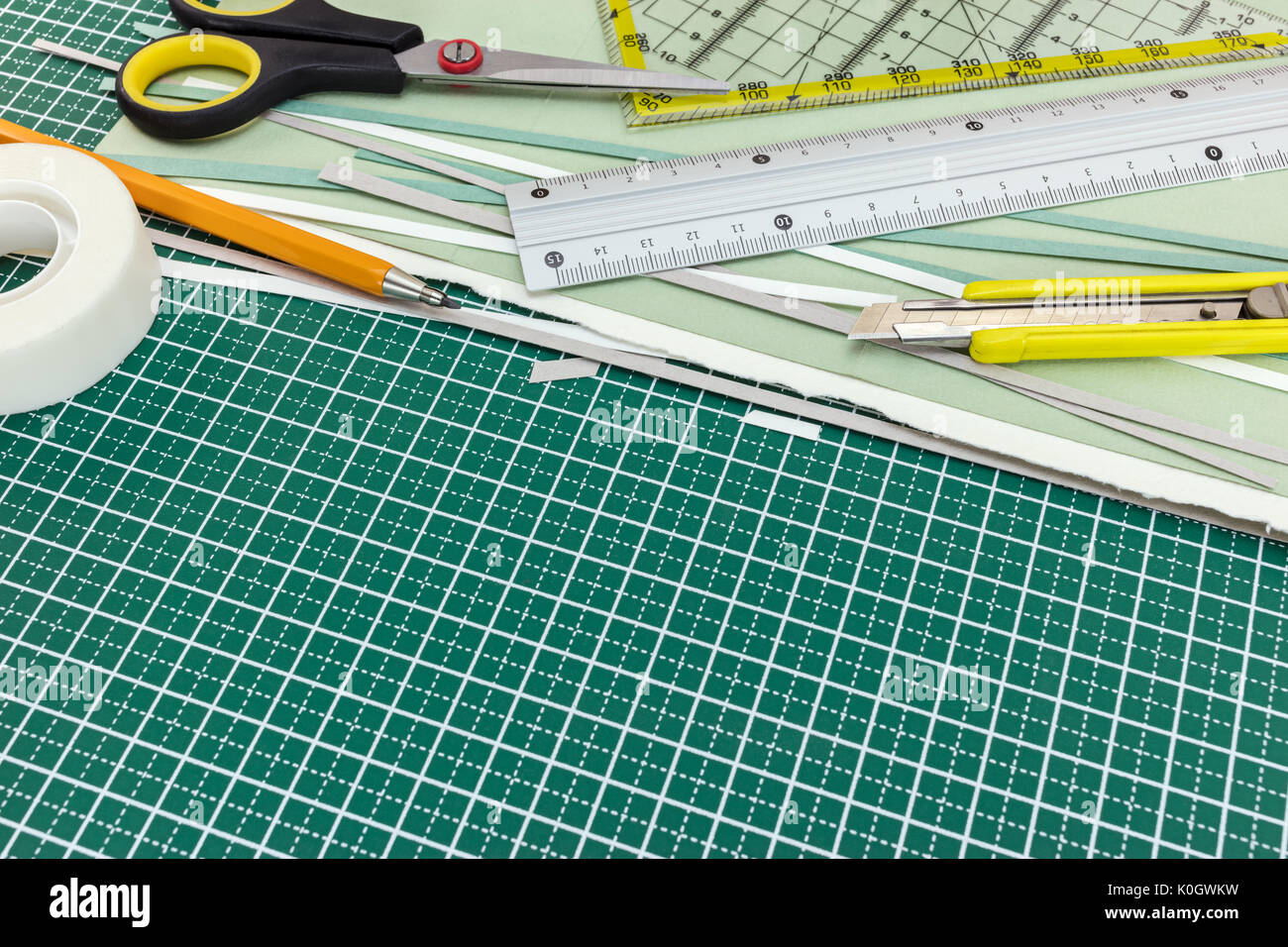 L'école et le bureau papeterie sur tapis de coupe : cutter, crayon, règle, ciseaux, ruban, des feuilles de papier Banque D'Images