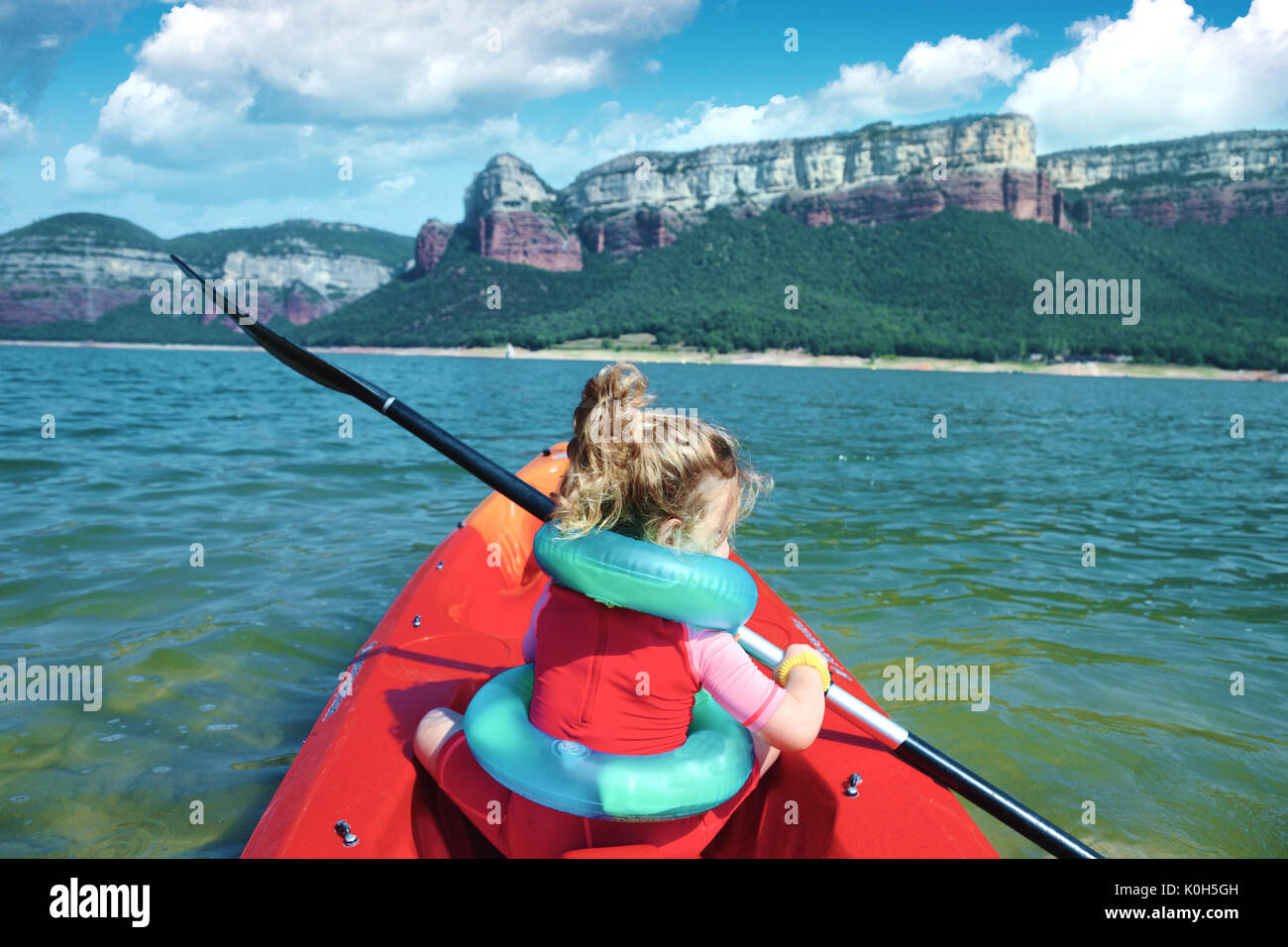 Fille blonde l'aviron dans un kayak jeter un lac en Catalogne, Espagne. Copie vide de l'espace pour l'éditeur de texte. Banque D'Images