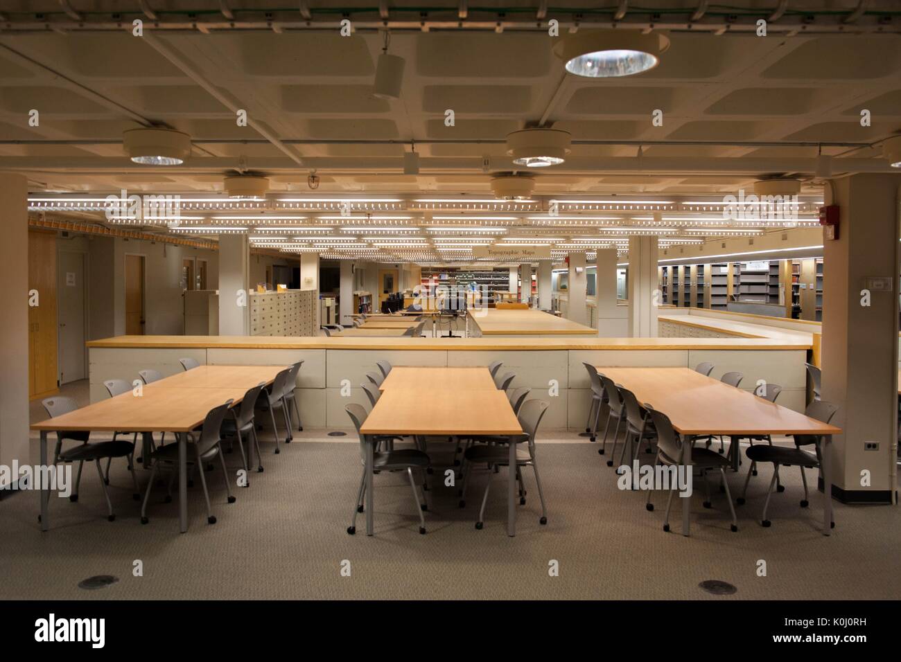 Un espace d'étude, complet avec des tables et des chaises sur roues, avec des piles et des classeurs visibles en arrière-plan, sur UN niveau de la bibliothèque Milton S. Eisenhower sur le campus Homewood de l'Université Johns Hopkins à Baltimore, Maryland, 2015. Avec la permission d'Eric Chen. Banque D'Images