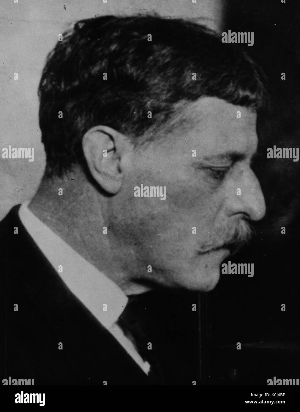 Head shot original de professeur de médecine Johns Hopkins, John Whitridge Wililams, portant un costume sombre et une chemise blanche, un profil tourné du côté droit de son visage, regardant vers le bas avec un sérieux de l'expression du visage. 1916. Banque D'Images