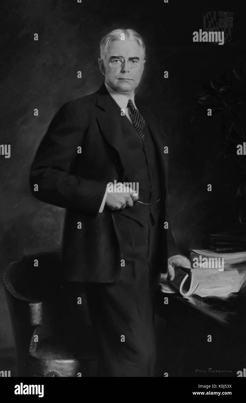 Trois-quarts de l'article American Lawyer et 49e gouverneur du Maryland Albert Cabell Ritchie, debout à côté d'un bureau et tenant un livre, Maryland, 1925. Banque D'Images