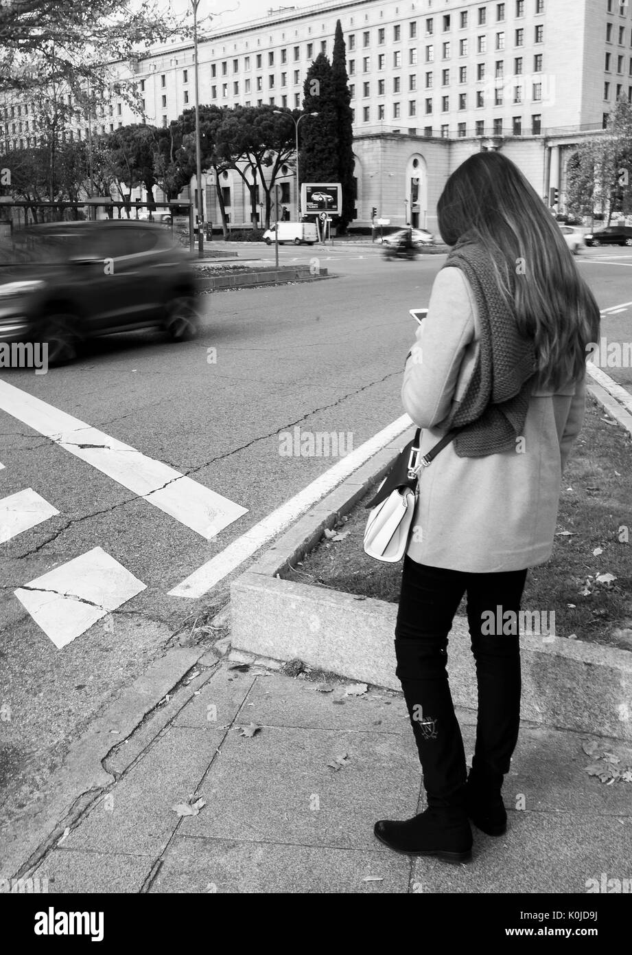 Chica esperando para cruzar el semáforo en la Plaza San Juan de la Cruz. La capitale de Madrid. España Banque D'Images