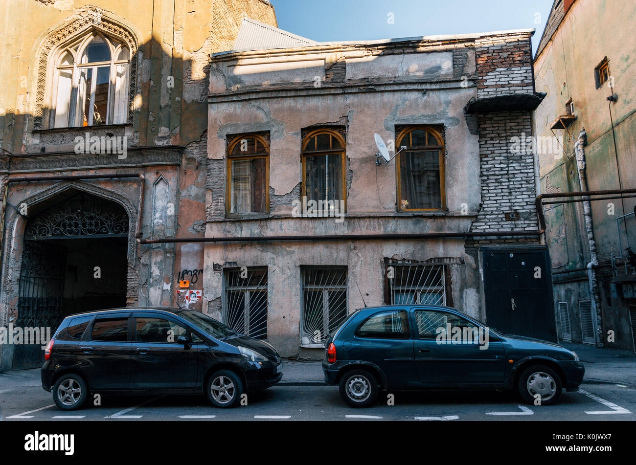 Tbilissi, Géorgie - 15 octobre 2016 : architecture ancienne délabrée à Tbilissi centre sur l'arrière-plan de voitures stationnées le long de la rue, la Géorgie. Banque D'Images