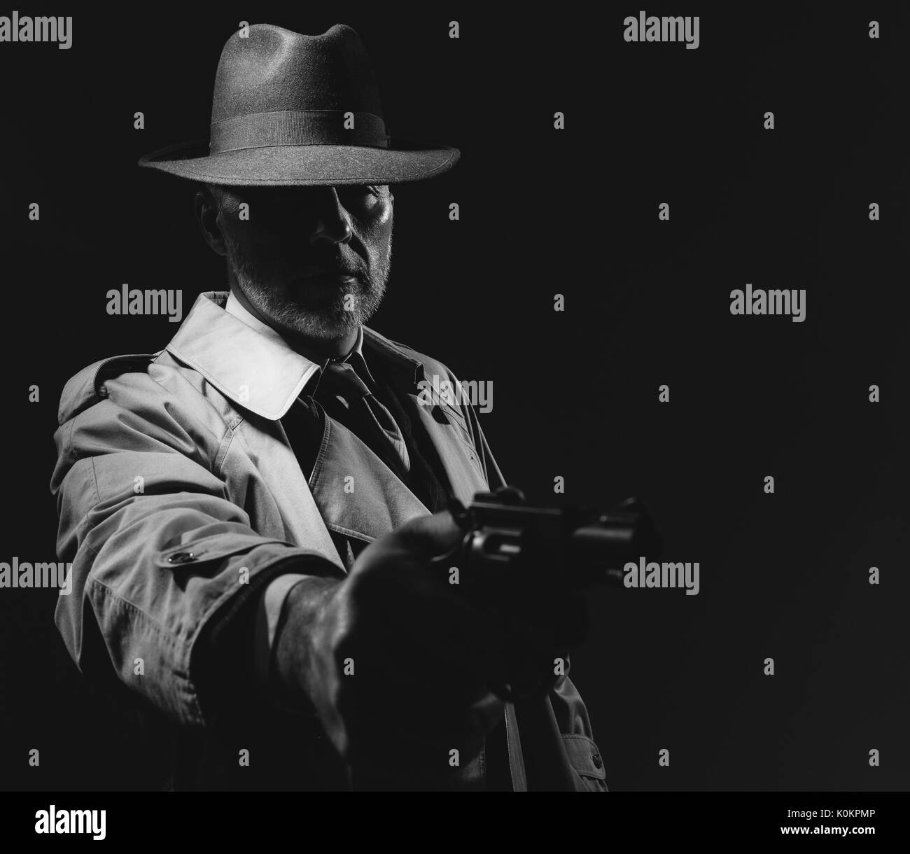 Incarnez un agent d'infiltration de braquer une arme dans le noir, 1950 film noir personnage masculin Banque D'Images