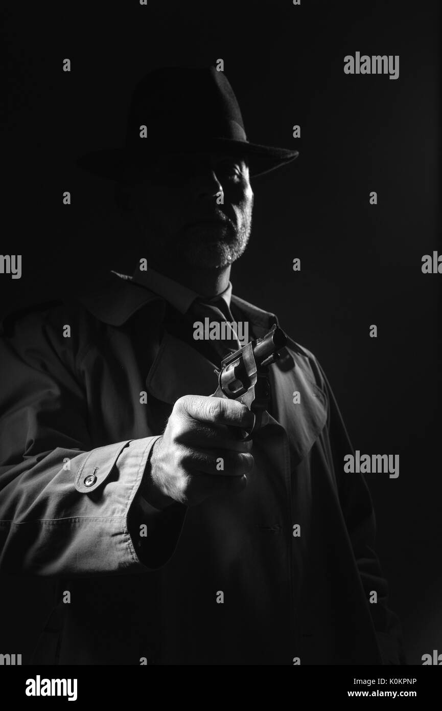 Incarnez un agent d'infiltration de braquer une arme dans le noir, 1950 film noir personnage masculin Banque D'Images
