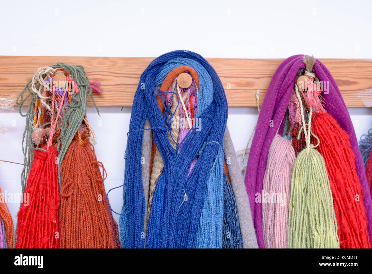 Hand Dyed et laine filées avec une gamme de coloris éclatants hanging on pegs en studio Banque D'Images