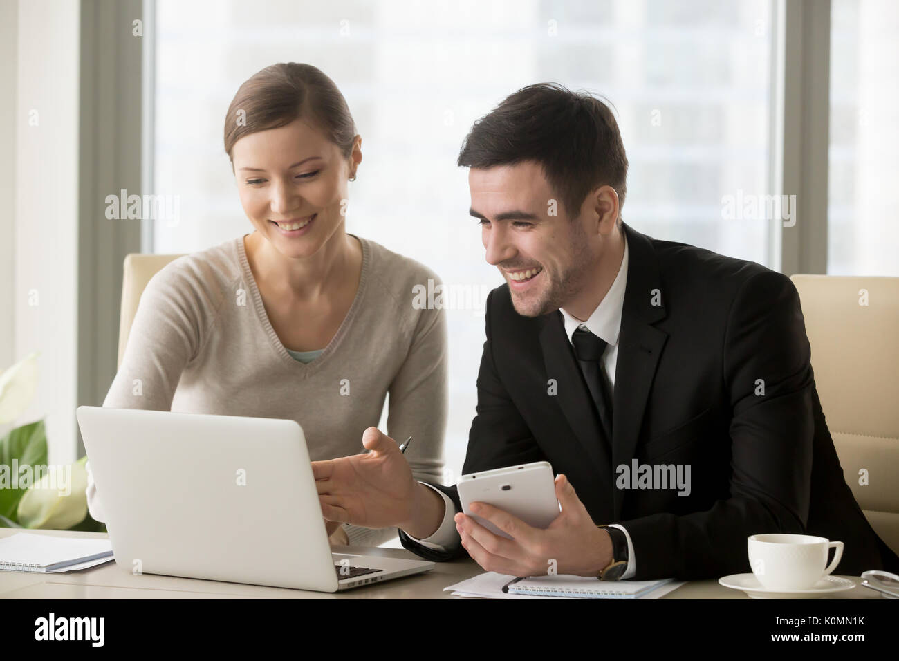 Smiling happy businesspeople using smart devices for mobile busi Banque D'Images