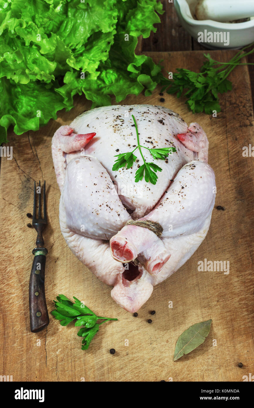 Poulet sur un fond de bois foncé, style rustique. Banque D'Images