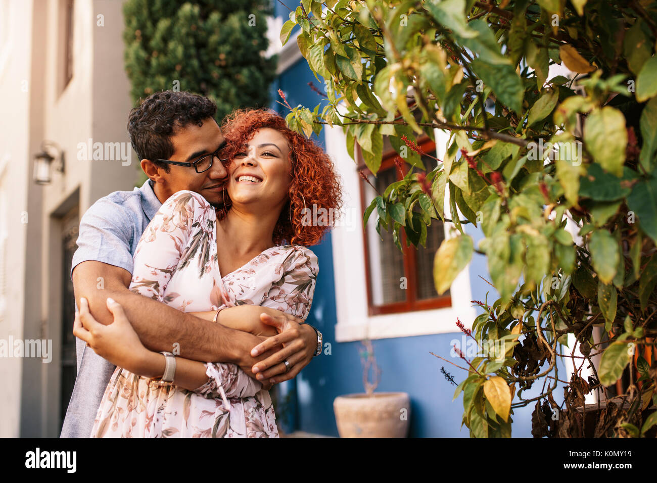 Couple de derrière dans l'expression de l'amour. Smiling woman holding part de son partenaire romantiquement avec son visage près de son visage. Banque D'Images