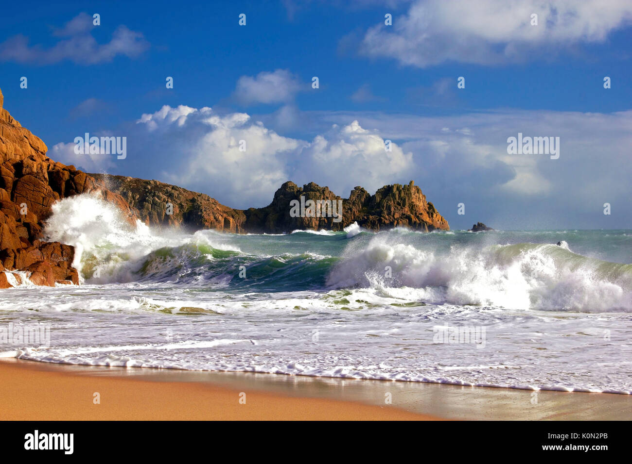 Une vue sur plage de porthcurno comme des vagues s'écraser sur les falaises Banque D'Images