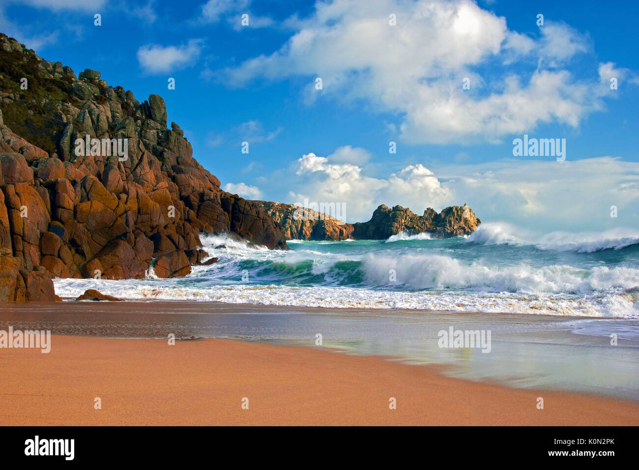 Une vue sur plage de porthcurno comme des vagues s'écraser sur les falaises Banque D'Images